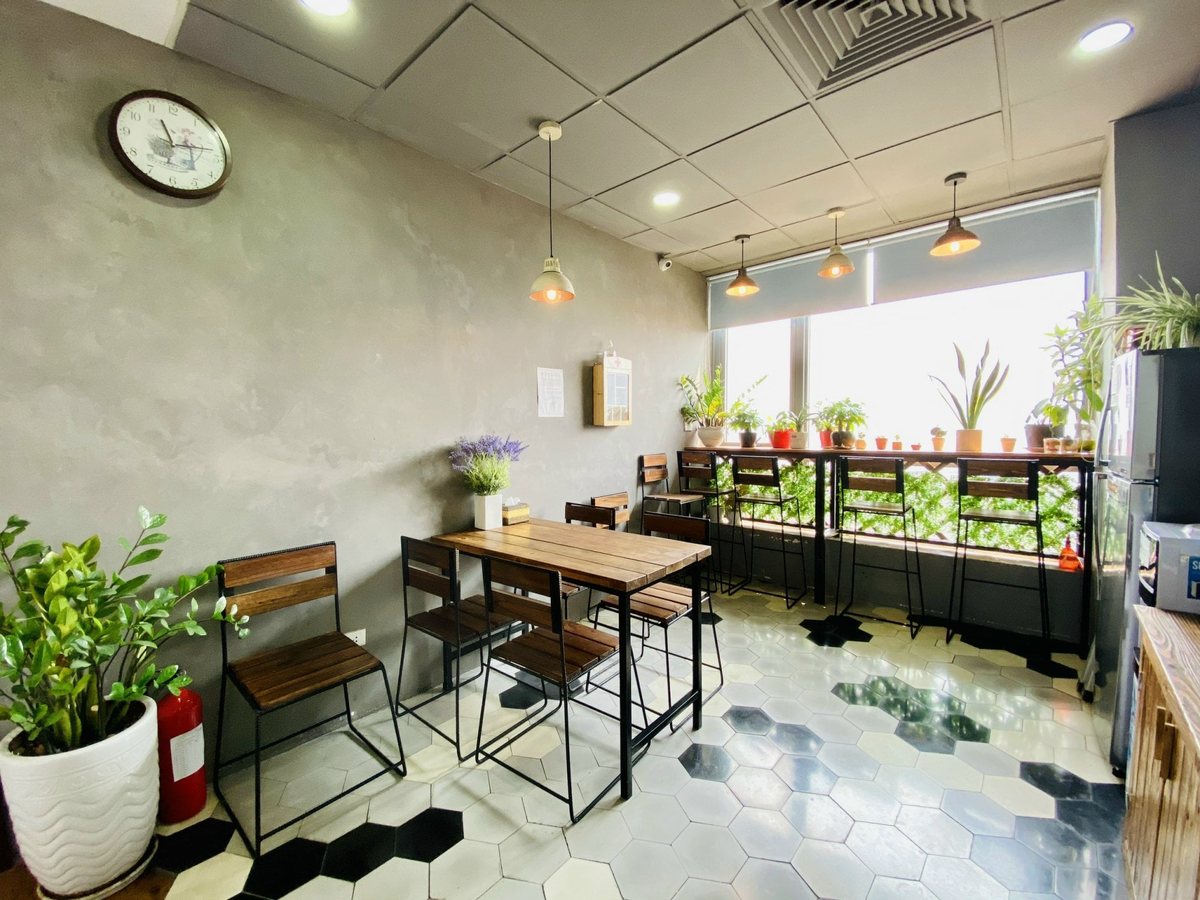 ROX Tower 88 Láng Hạ – khu pantry Khu pantry có bàn ghế cạnh cửa kính trong một văn phòng tại tòa nhà